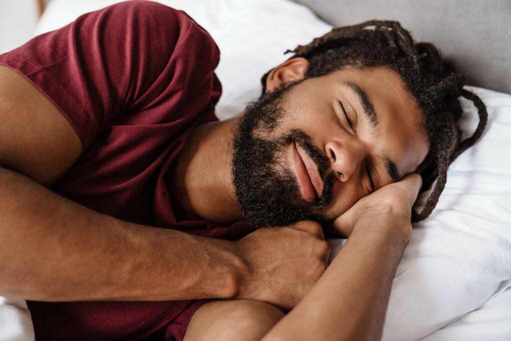 Man sleeping peacefully in bed representing sleep optimization and a functional health approach to recovery and long-term wellness