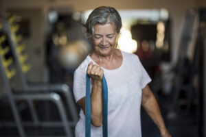 Woman using resistance bands for exercise for healthy aging and resistance training after 40 to support strength and mobility.
