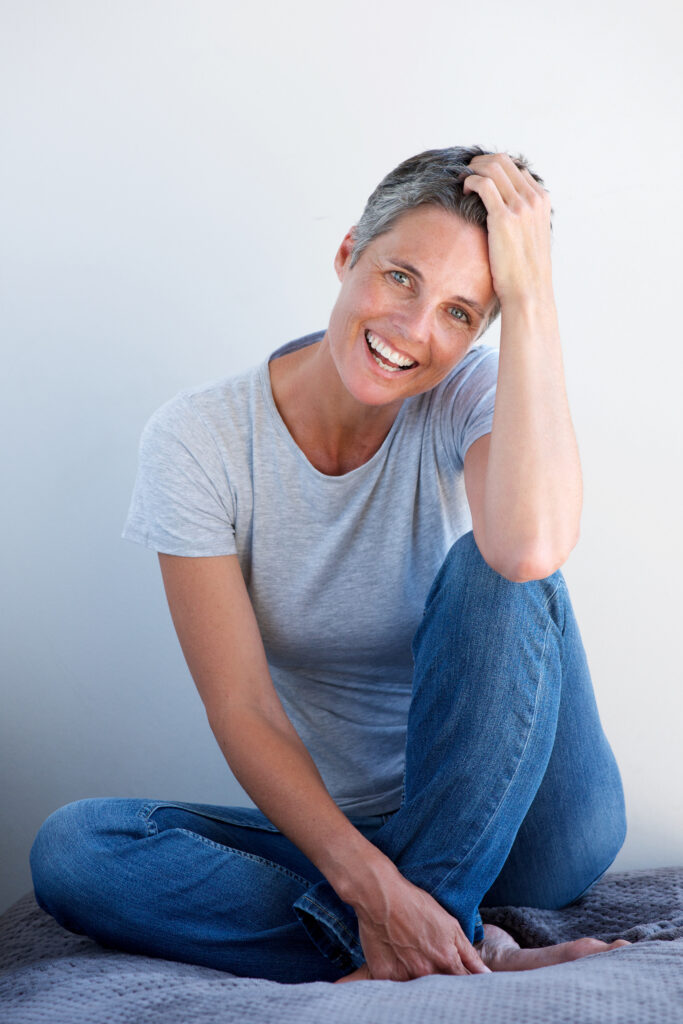 Smiling mature woman representing hormonal health and hormone optimization for women as hormone levels change with age.